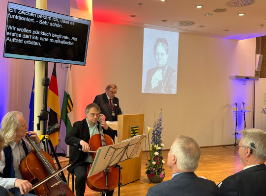 Dr. Matthias Müller am Pult, davor 2 Musiker